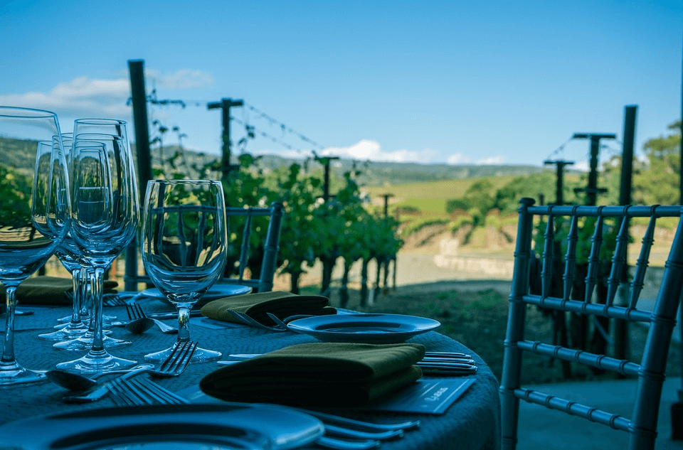 Outdoor dining setup at a winery in Dunsborough, showing wine glasses on a table with a scenic vineyard backdrop, perfect for wine lovers seeking the finest wine experiences in Dunsborough