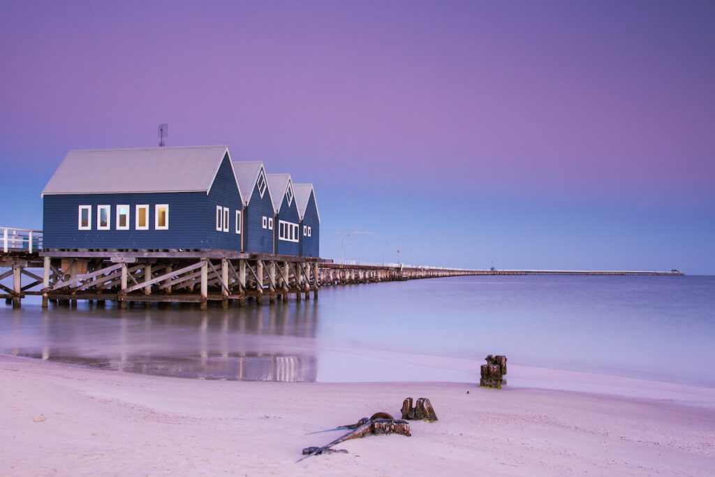 Purple sunset skies above the Busselton Jetty with a blue cottage at the start of the jetty