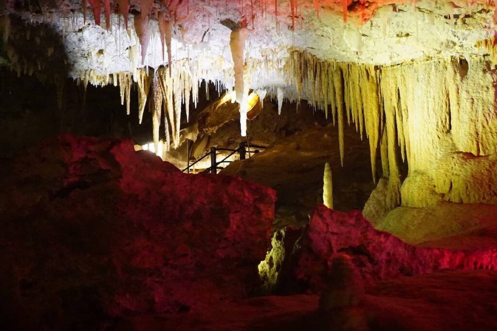 Illuminated view inside Ngilgi Cave in Dunsborough, WA, highlighting the intricate limestone formations and stalactites