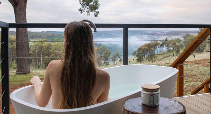 A woman sitting in an outdoor bath tub