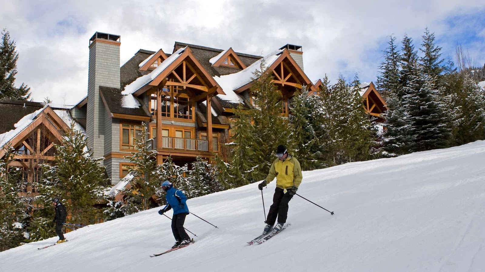 Three people skiing down a snowy slope