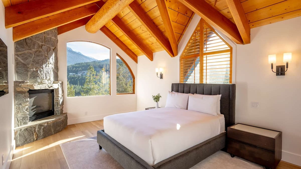 Primary bedroom with wooden ceilings and stone fireplace