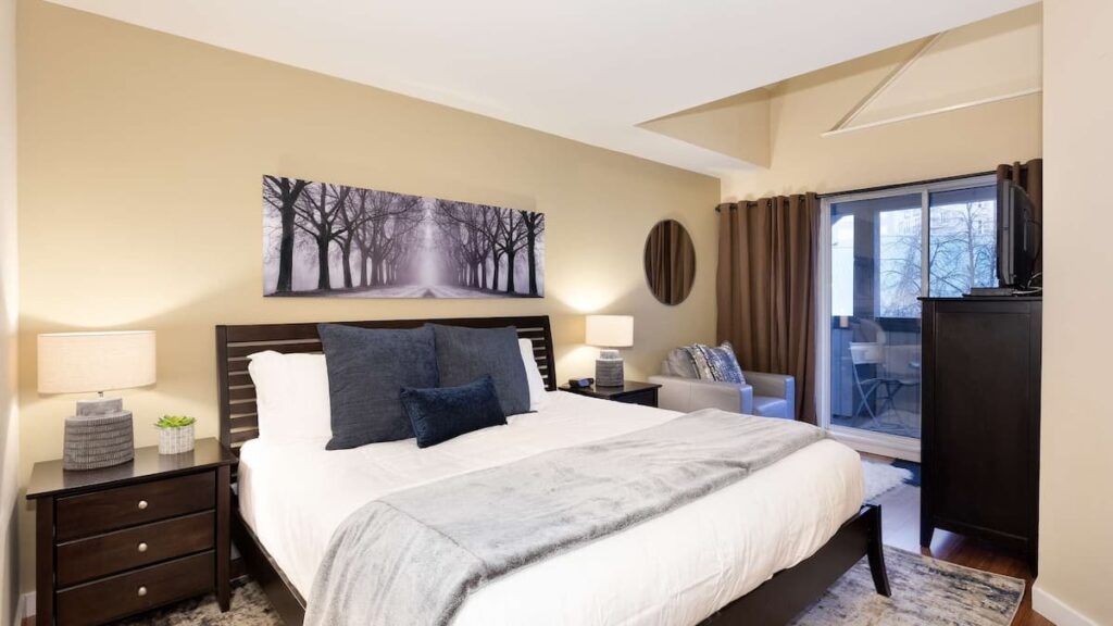 Primary bedroom with black furnishings and sliding doors out to private patio