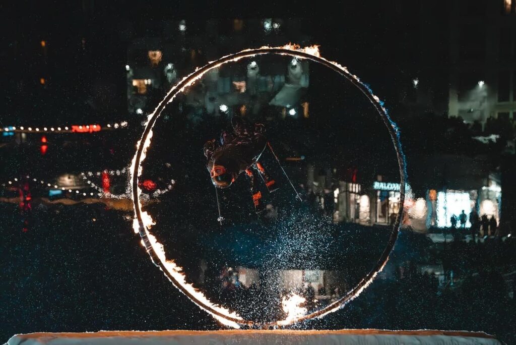 Skier jumping through ring of fire on Whistler slopes