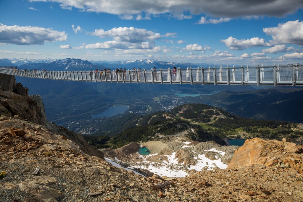 Tourists enjoying mountain views from Whistler Blackomb's alpine on the Cloudraker Skybridge